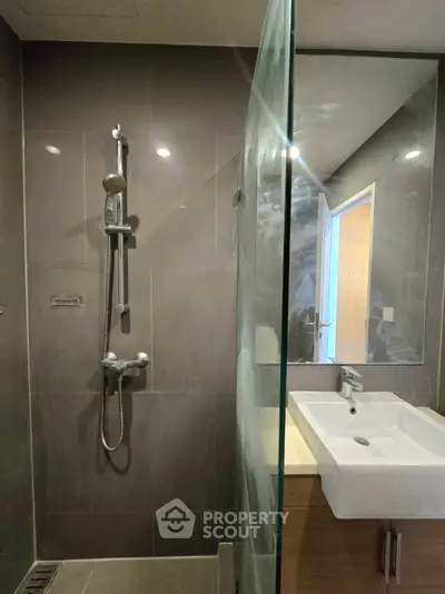 Modern bathroom with sleek shower and stylish sink in contemporary apartment.
