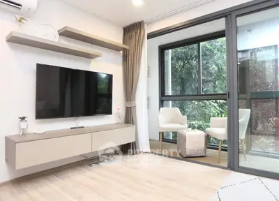 Modern living room with large TV and balcony view, featuring elegant decor and natural light.