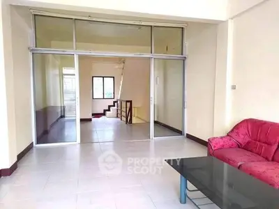 Spacious living room with glass doors and modern furniture in a bright apartment.