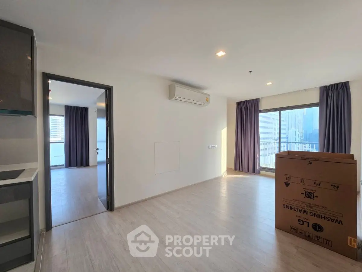 Spacious modern apartment with open layout and city view, featuring a new washing machine.