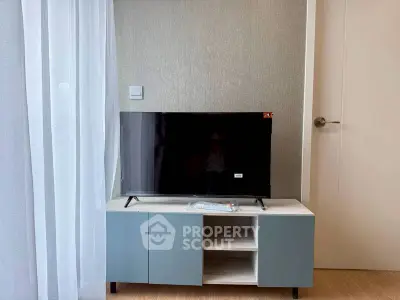 Modern living room with sleek TV stand and flat-screen TV, perfect for cozy entertainment.