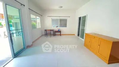 Spacious living room with large windows and minimalistic furniture in a bright, airy home.