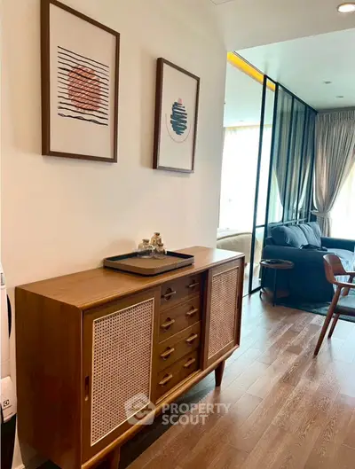 Stylish living room with modern decor and wooden furniture, featuring elegant artwork and natural light.
