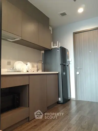 Modern kitchen with sleek cabinetry and stainless steel appliances in a stylish apartment.