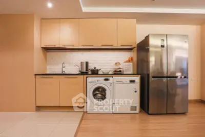 Modern kitchen with sleek appliances including fridge and washing machine, stylish cabinetry, and tiled backsplash.