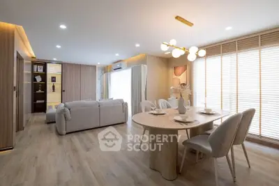 Spacious modern living room with elegant dining area and natural light.