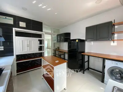 Modern kitchen with sleek black appliances and wooden countertops