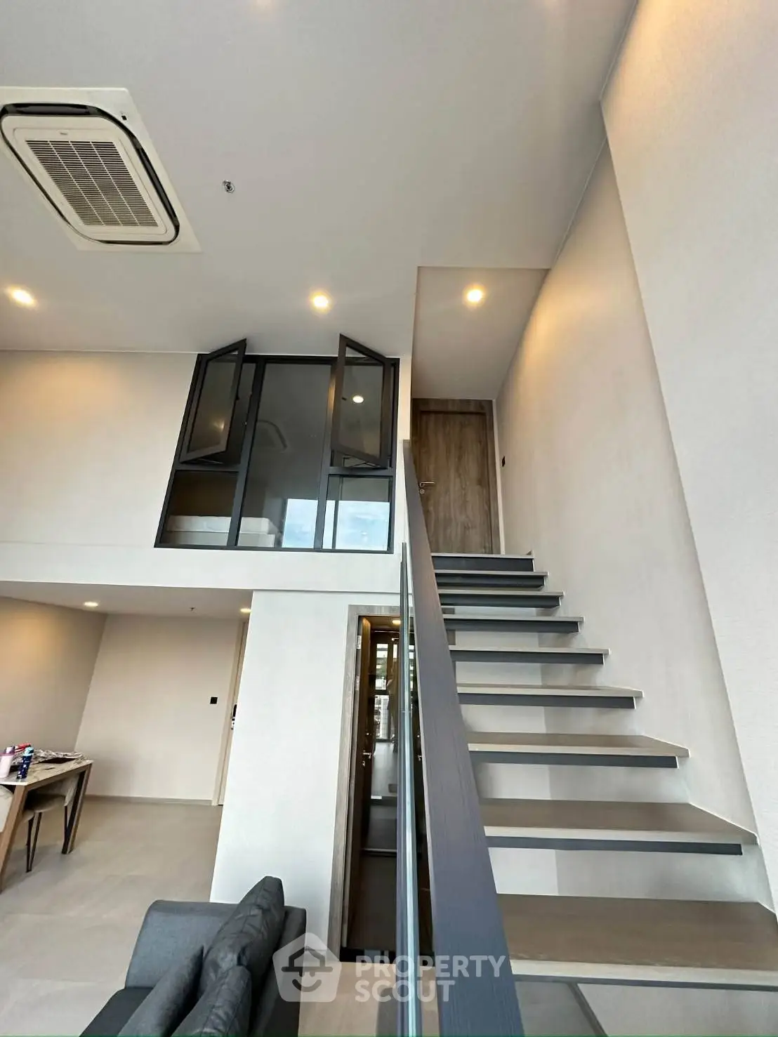 Modern loft apartment with sleek staircase and high ceilings, featuring a stylish mezzanine and contemporary design.