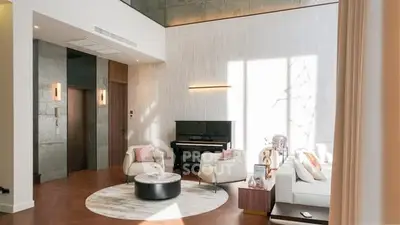 Luxurious living room with high ceilings and elegant decor, featuring a piano and modern furniture.