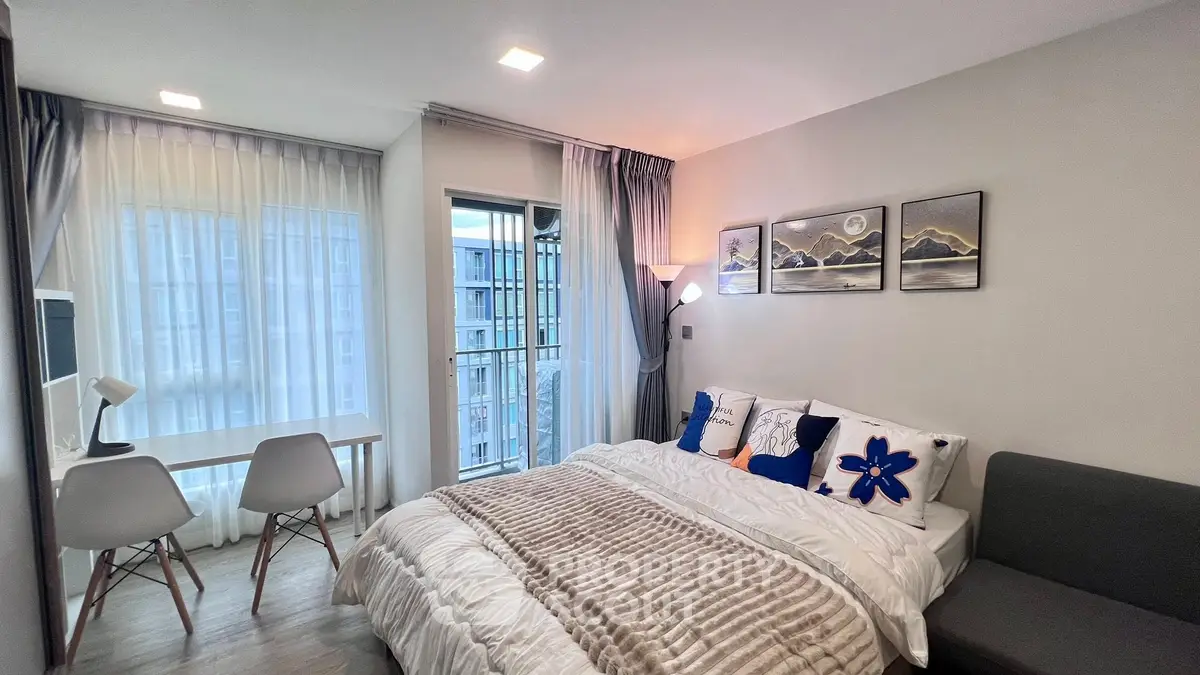 Modern bedroom with balcony access and stylish decor in a cozy apartment.