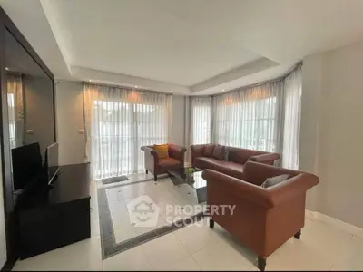 Spacious living room with elegant sofas and large windows for natural light.