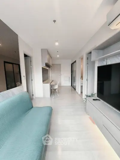 Modern living room with sleek design and open layout, featuring a stylish sofa and built-in TV unit.