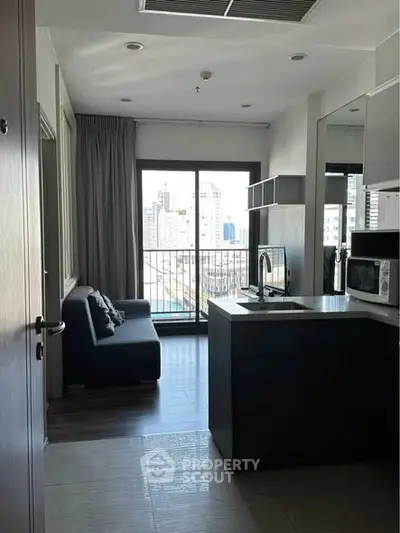Modern apartment with open kitchen and city view balcony, featuring sleek design and natural light.