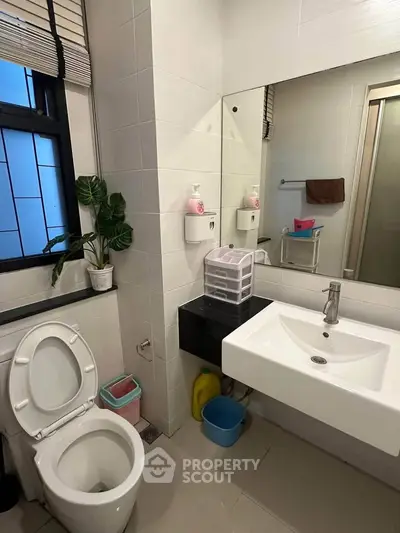 Modern bathroom with sleek fixtures and ample natural light, featuring a stylish sink and toilet.