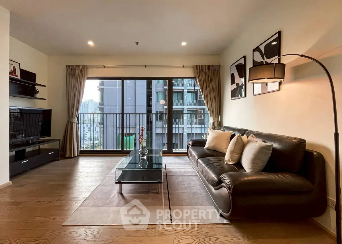 Spacious modern living room with elegant decor and large windows offering city views.