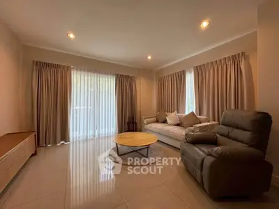 Spacious living room with modern furniture and natural light, perfect for relaxation and entertainment.