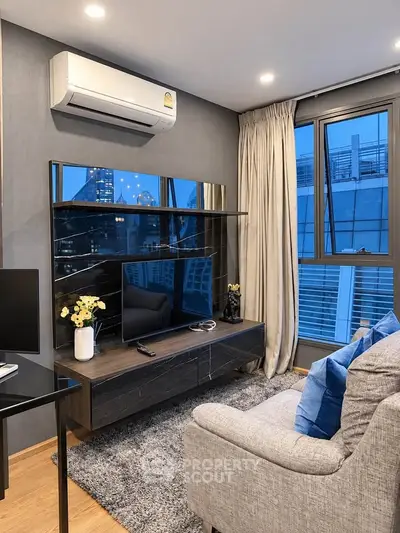 Modern living room with stylish decor and city view, featuring a sleek entertainment unit and cozy seating.