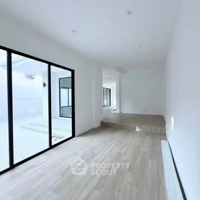 Spacious modern living room with large windows and wooden flooring