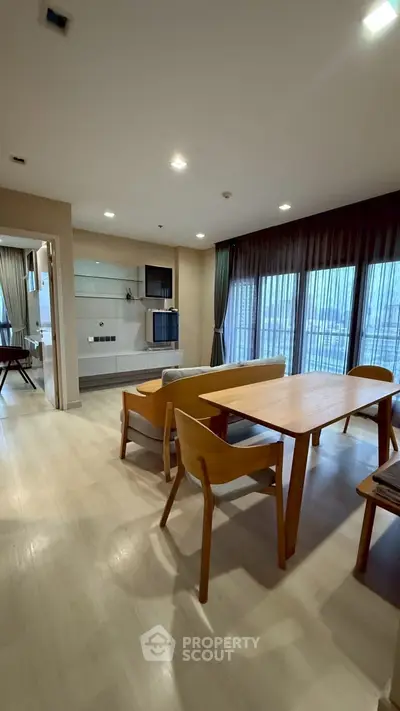 Spacious modern living room with elegant wooden furniture and large windows offering natural light.