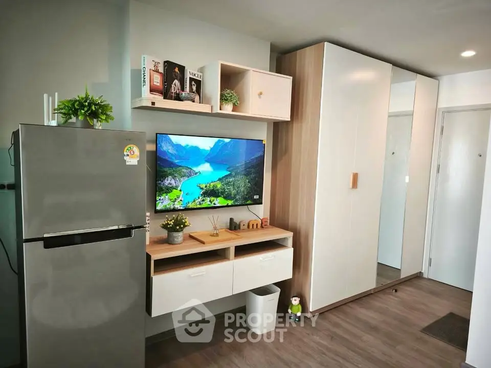 Modern living room with sleek storage and mounted TV in stylish apartment.