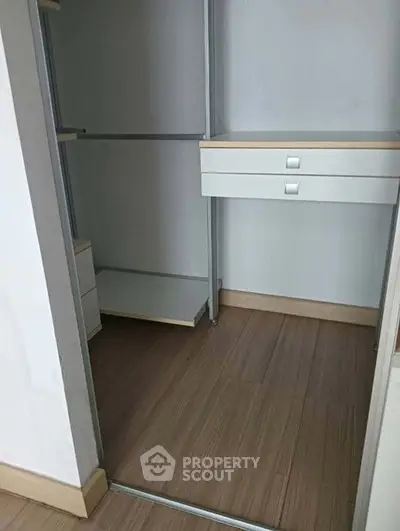 Spacious walk-in closet with modern shelving and drawers, perfect for organized storage.