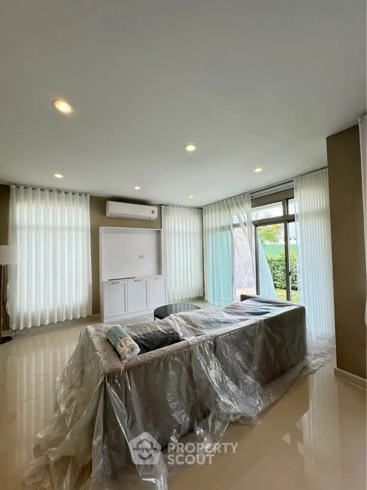 Spacious living room with modern decor and large windows for natural light