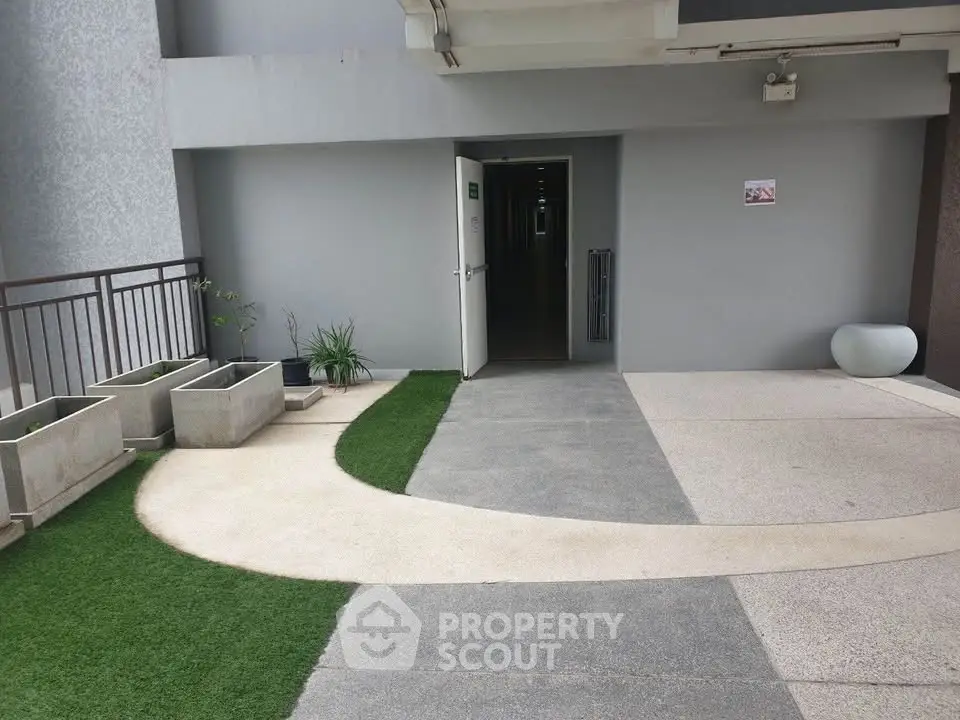 Modern apartment building entrance with stylish walkway and planters.