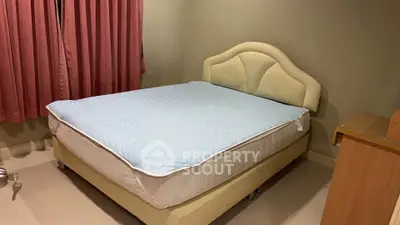Cozy bedroom with a comfortable bed and elegant headboard, perfect for relaxation.