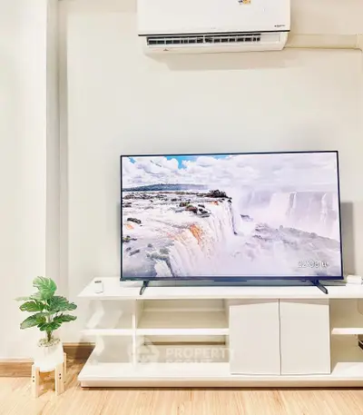Modern living room with sleek TV and air conditioner, showcasing stylish decor and wooden flooring.