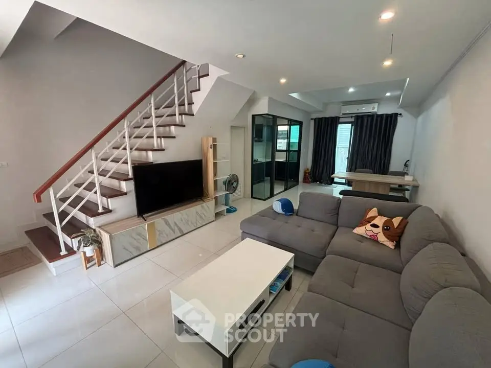 Spacious living room with modern decor and stylish staircase