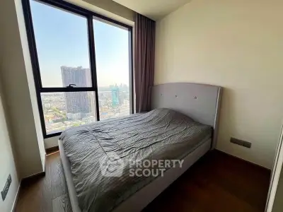 Modern bedroom with stunning city view from large window, featuring a sleek bed and minimalist decor.