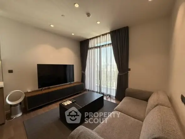 Modern living room with large TV, stylish sofa, and floor-to-ceiling windows with curtains.