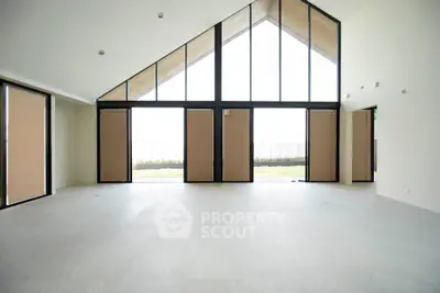 Spacious modern living room with high ceilings and large windows offering abundant natural light.