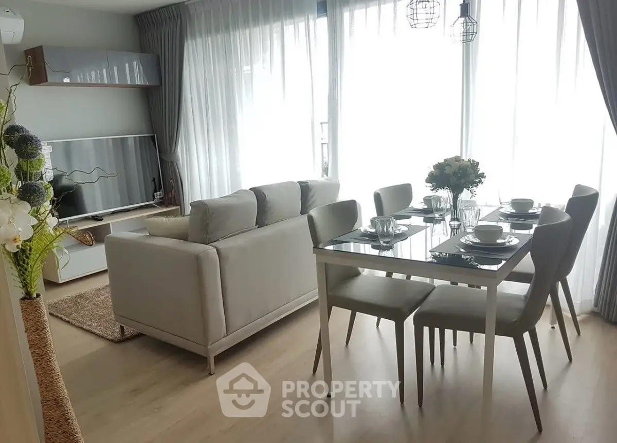 Modern living room with elegant dining area and large windows for natural light.