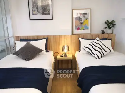 Chic modern bedroom with twin beds, stylish decor, and cozy ambiance perfect for urban living.