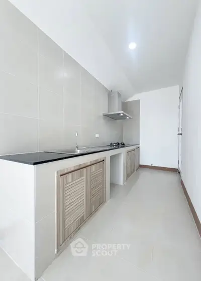 Modern kitchen with sleek closed layout and gas stove, perfect for culinary enthusiasts.