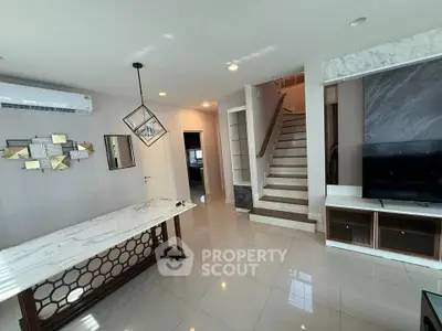 Modern living room with stylish decor and staircase in a contemporary home.