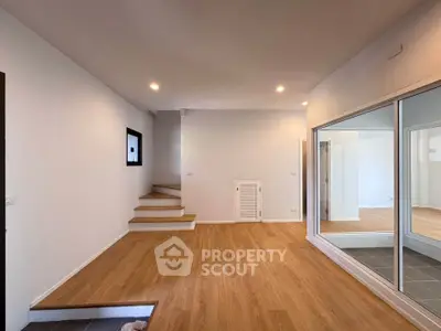 Spacious modern living room with wooden flooring and staircase