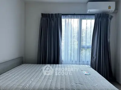 Cozy bedroom with large window and air conditioning unit, perfect for restful nights.