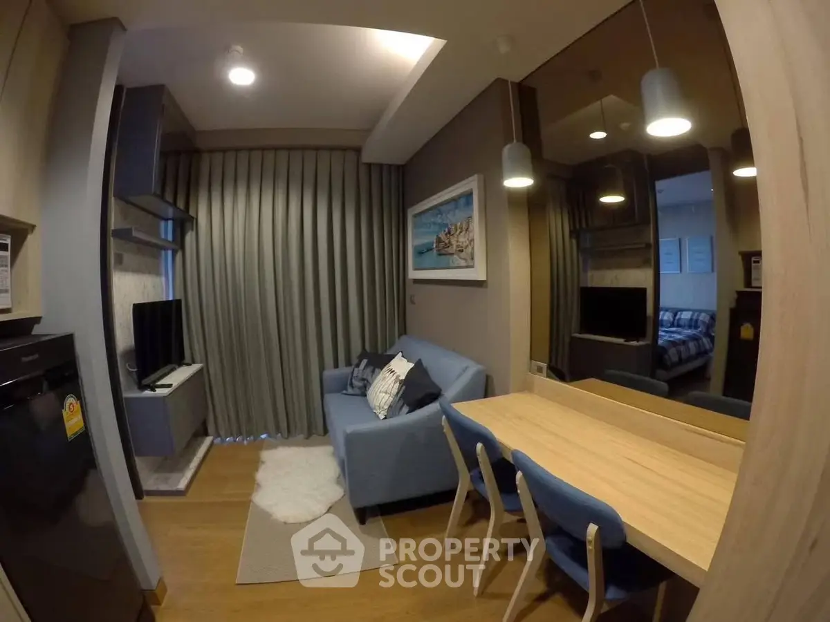 Modern living room with cozy blue sofa and dining area in stylish apartment