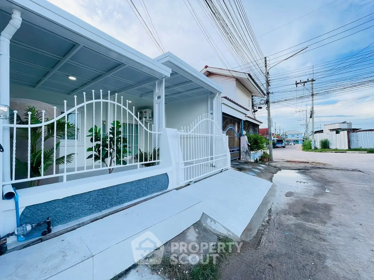 Charming modern house exterior with white fence and driveway in a serene neighborhood.