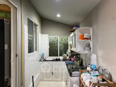 Compact kitchen with closed layout and gas stove, featuring modern cabinets and appliances.