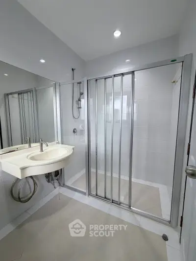 Modern bathroom with sleek shower enclosure and stylish sink in a contemporary home.