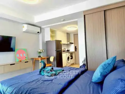 Modern studio apartment with cozy bedroom and compact kitchen, featuring stylish decor and efficient use of space.
