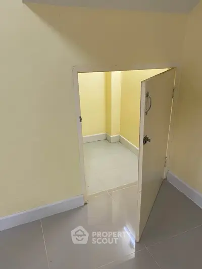 Unique small storage room with yellow walls and tiled floor, perfect for compact spaces.