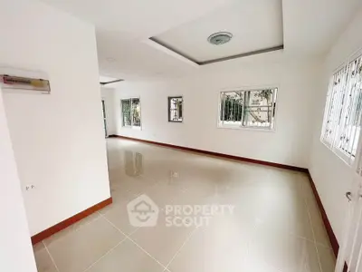 Spacious unfurnished room with large windows and tiled flooring