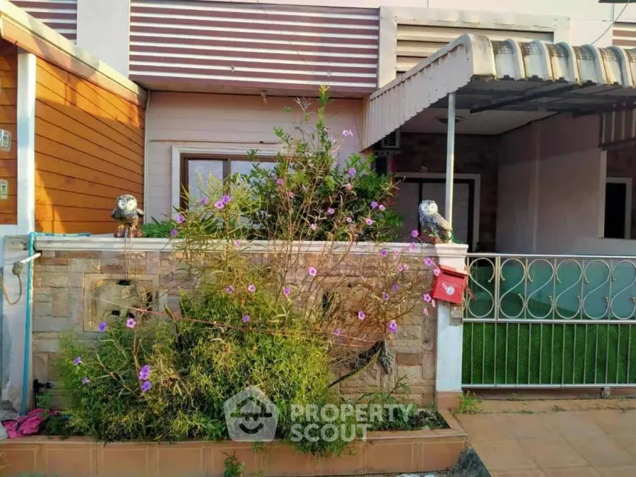 Charming house exterior with lush garden and decorative elements.