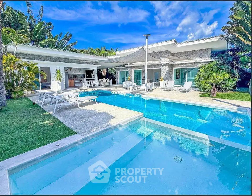 Luxurious villa with stunning pool and lush garden, perfect for tropical living.
