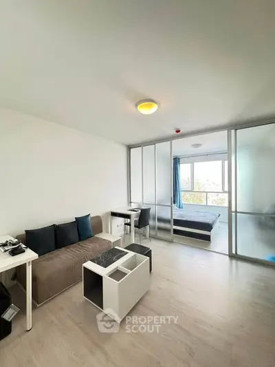 Modern studio apartment with sliding glass partition and stylish furnishings