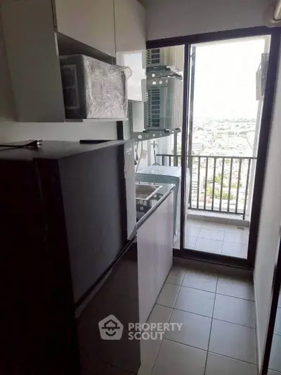 Compact kitchen with balcony view in modern apartment